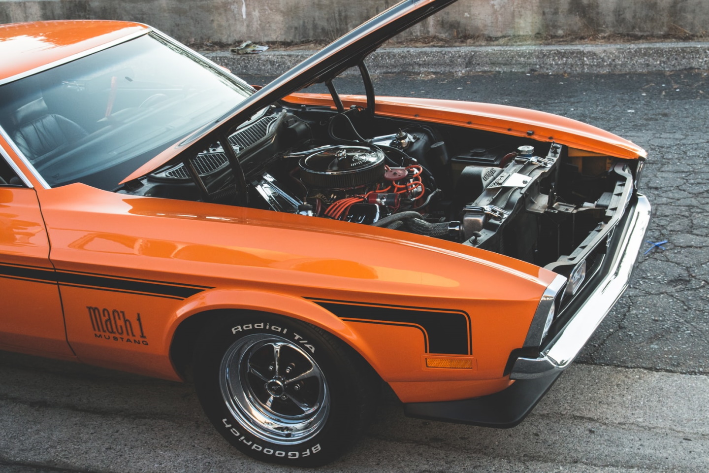 An orange mustang with the bonnet open